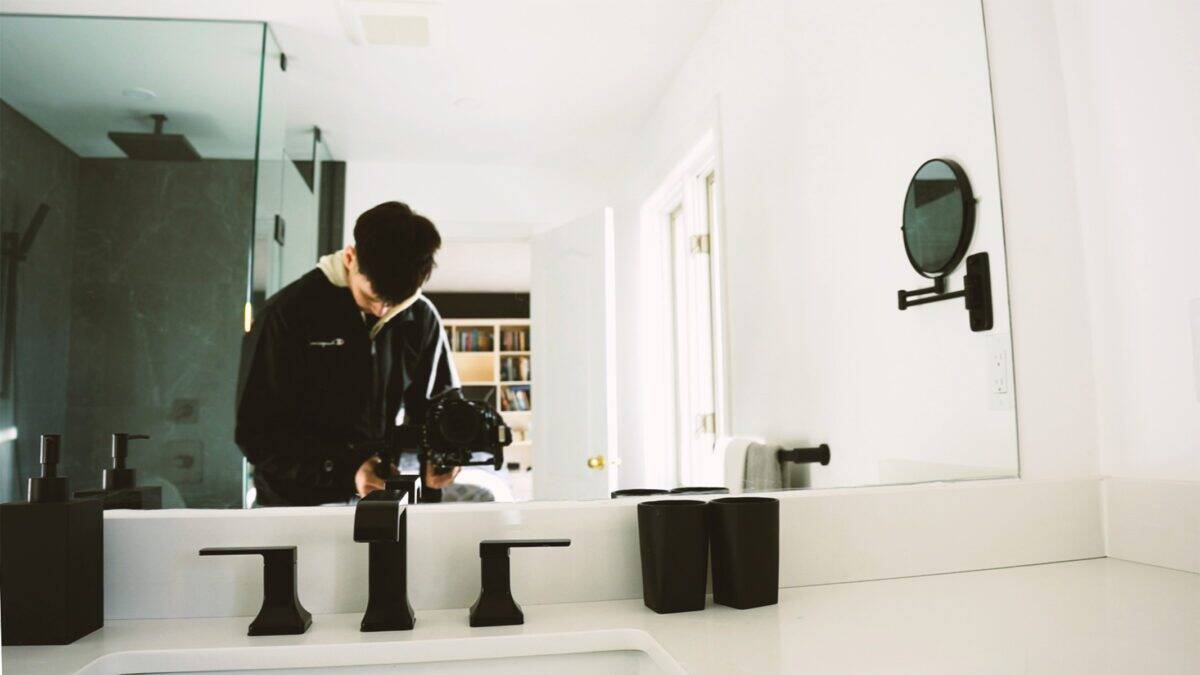 Geoffrey Faber filming a video in a bathroom.