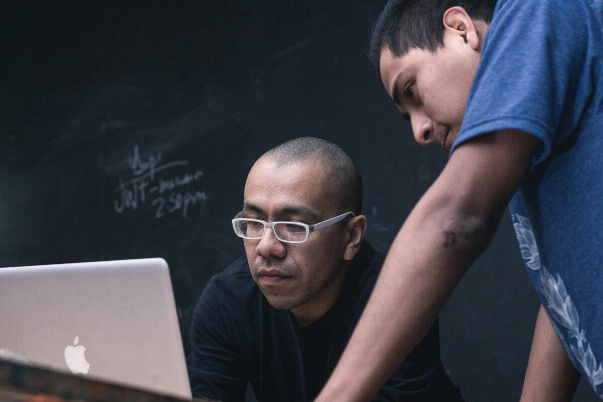 Two marketing specialists looking at a laptop together.